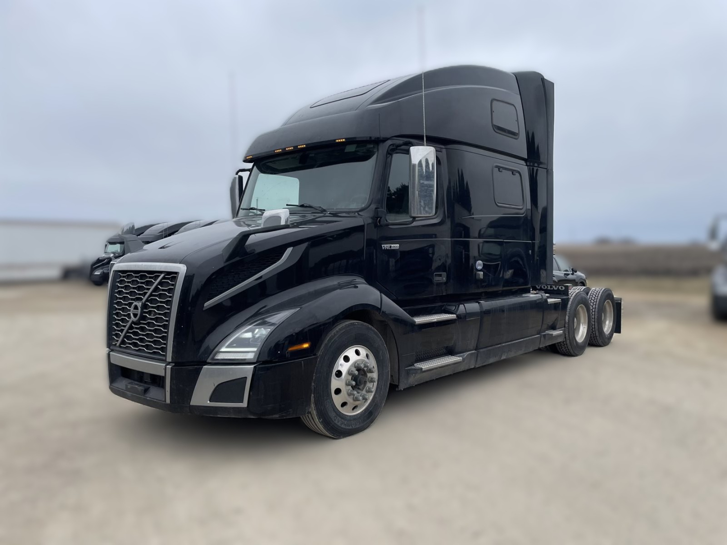 Volvo VNL860 semi-truck cab in black, front three-quarter view, with sleeper, large grille, chrome mirrors, and side step.