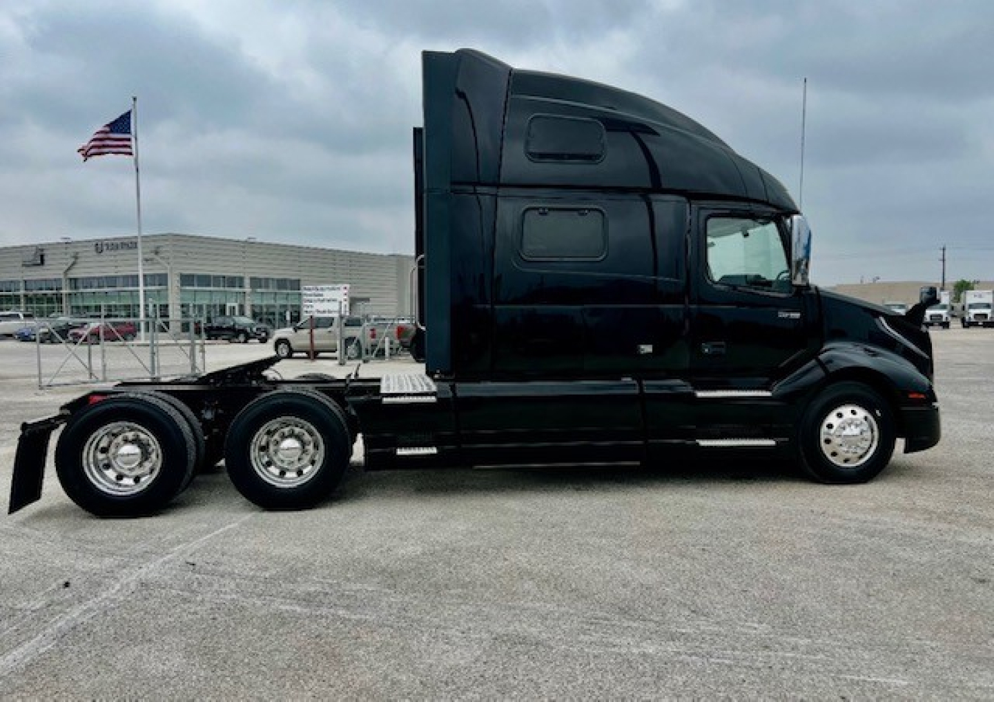Volvo VNL860 truck side view showing sleeper cab and three rear axles, with no visible text on the body.