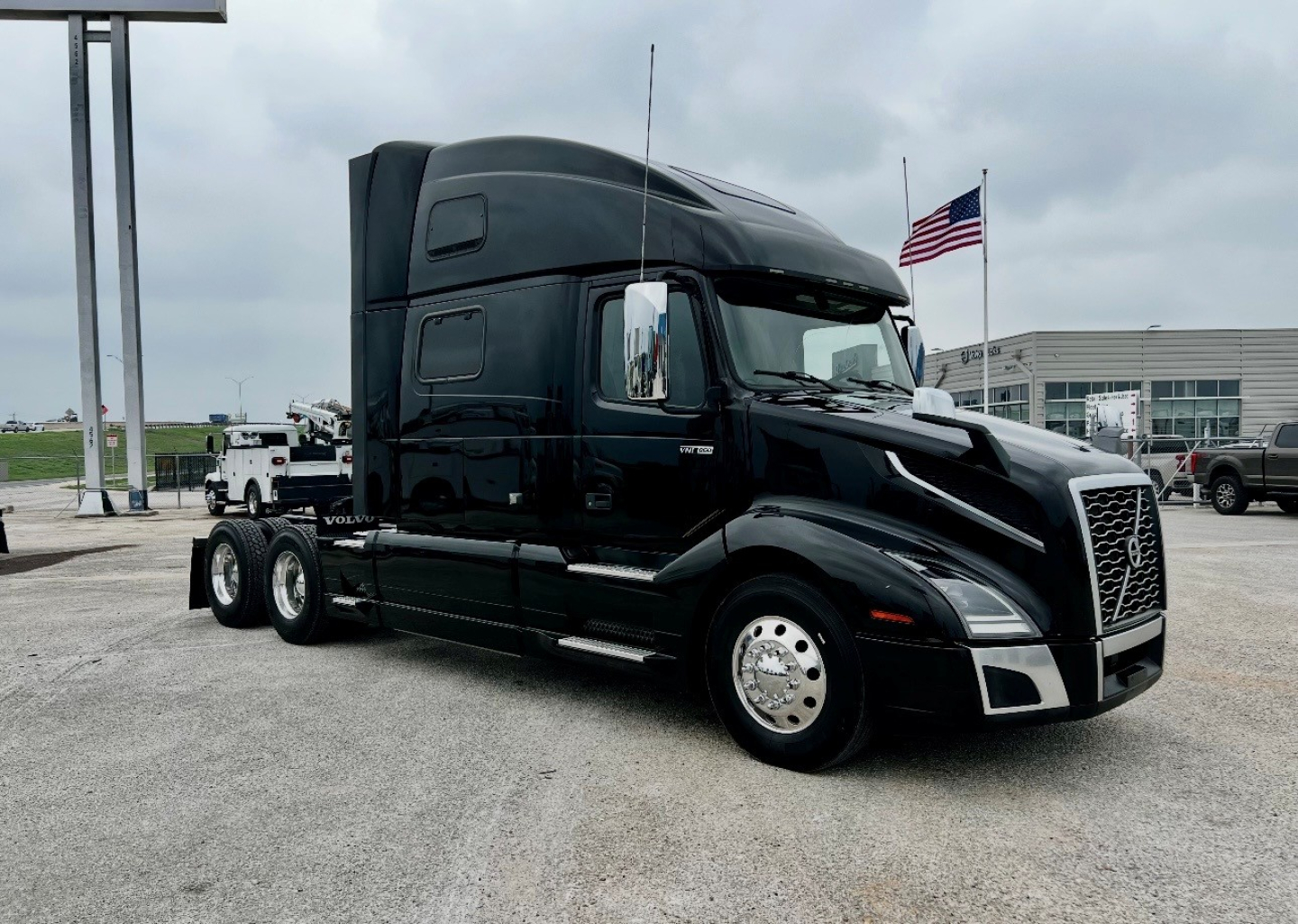 Volvo VNL860 heavy-duty truck tractor in black, side view with sleeper cab and chrome wheels.