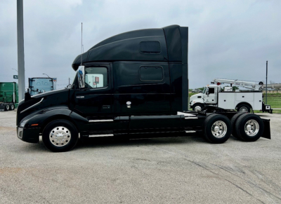 Volvo VNL860 sleeper cab tractor in service showing side profile and 6x4 axle configuration.