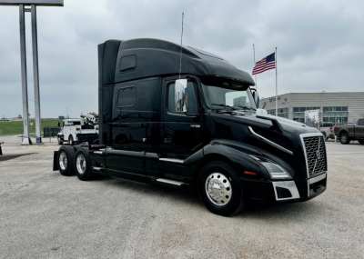 Volvo VNL860 heavy-duty truck tractor in black, side view with sleeper cab and chrome wheels.