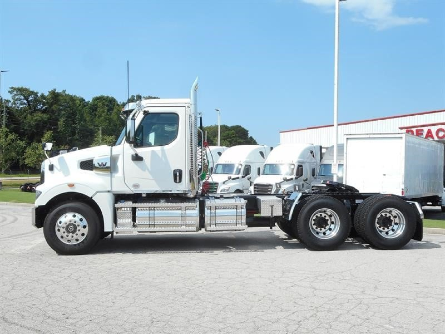 Truck side view showing 2027 Western Star 49X day cab with white cab, long chassis, and dual rear axles.