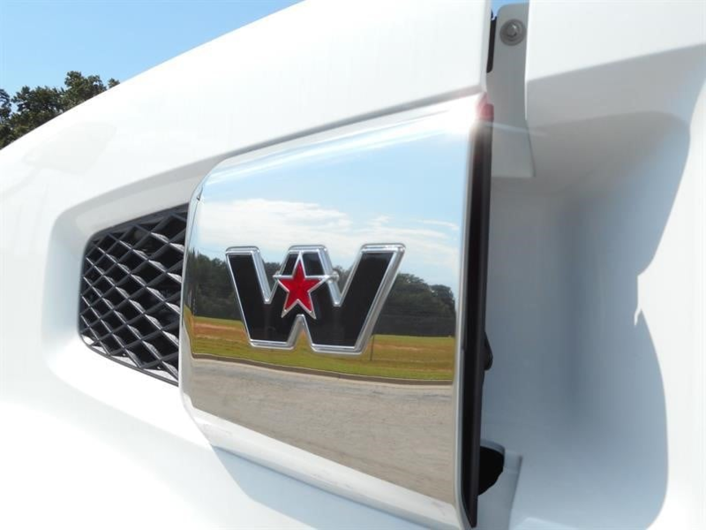 Western Star truck front grille and emblem on white truck showing chrome logo with red star