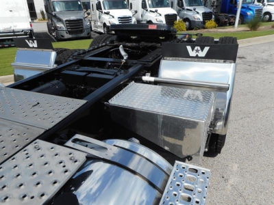 Western Star 49X chassis near cab area with polished aluminum tool boxes and chrome fuel tank, black frame, and metal deck plates visible.