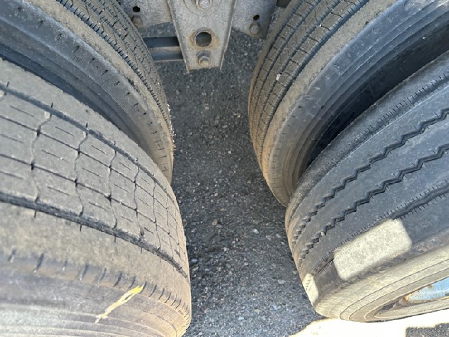 Trailer wheels close-up showing dual tires with tread and sidewall details, part of a used flatbed trailer undercarriage.