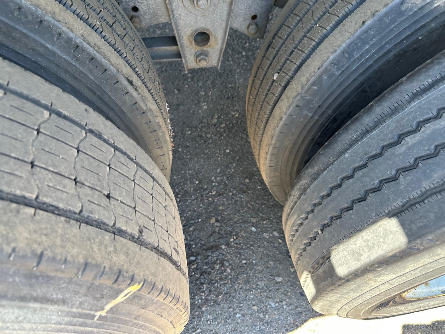 Dual rear tires of a Utility 4000AE trailer showing tread, sidewall details, and wheel hubs.