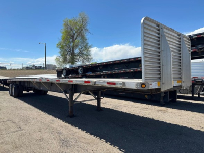 Flatbed trailer with ramp-in rear showing utility 4000Ae equipment and extended flatbed.