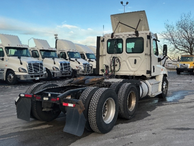 Freightliner Cascadia125 truck tractor in a lot, rear view shows fifth wheel area and dual rear axles with mud flaps.