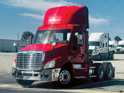 Freightliner Cascadia125 daycab tractor in red, front-left view with chrome bumper and dual rear axles, cargo area visible.