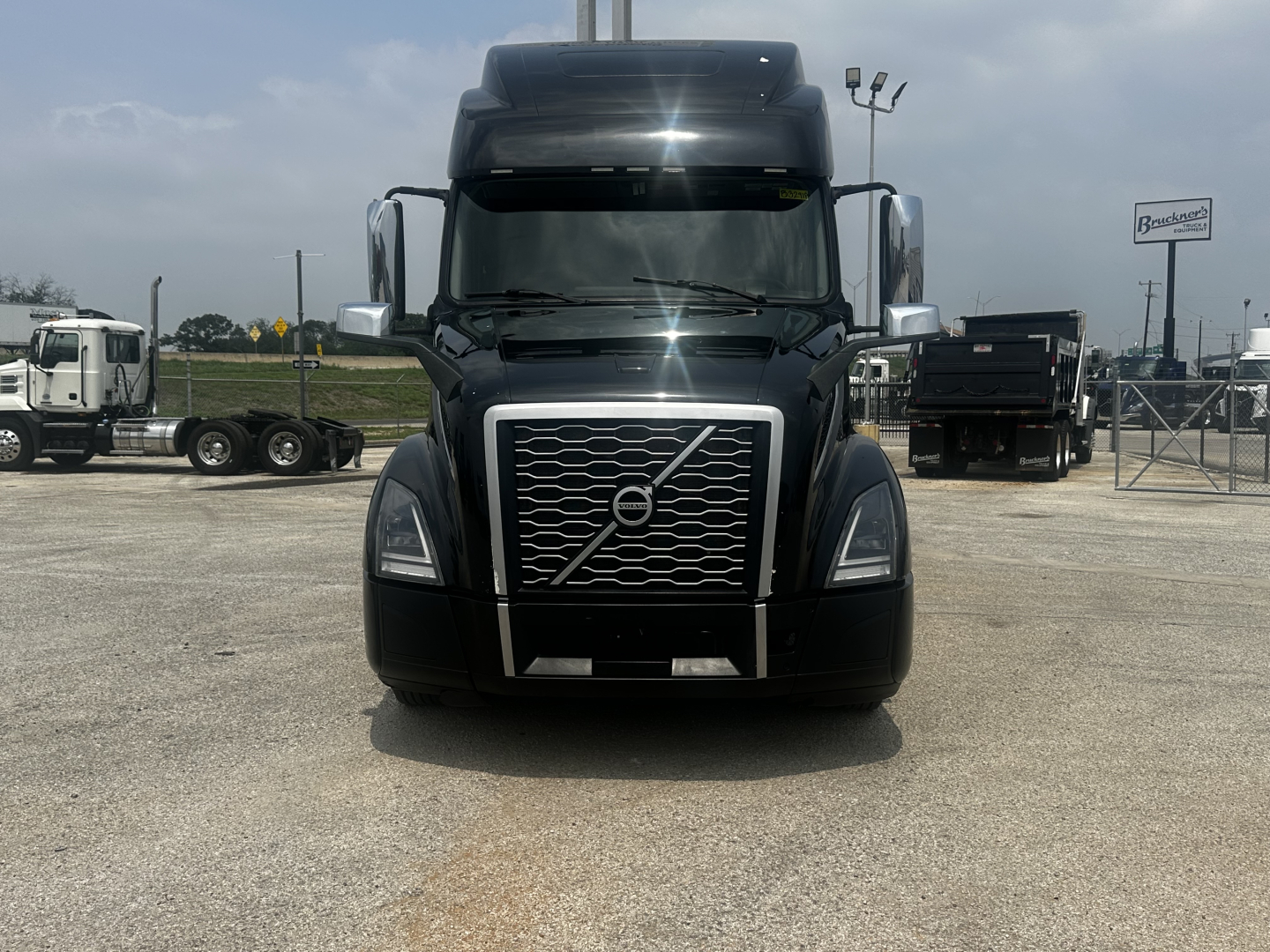  Volvo VNL860 front view showing large chrome grille with diagonal Volvo emblem and black bumper. 
