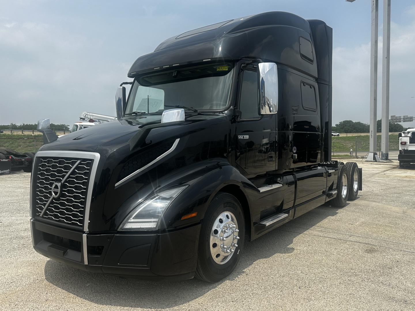 Volvo VNL860 sleeper cab truck in black showing grille and side view with chrome mirrors and wheels.