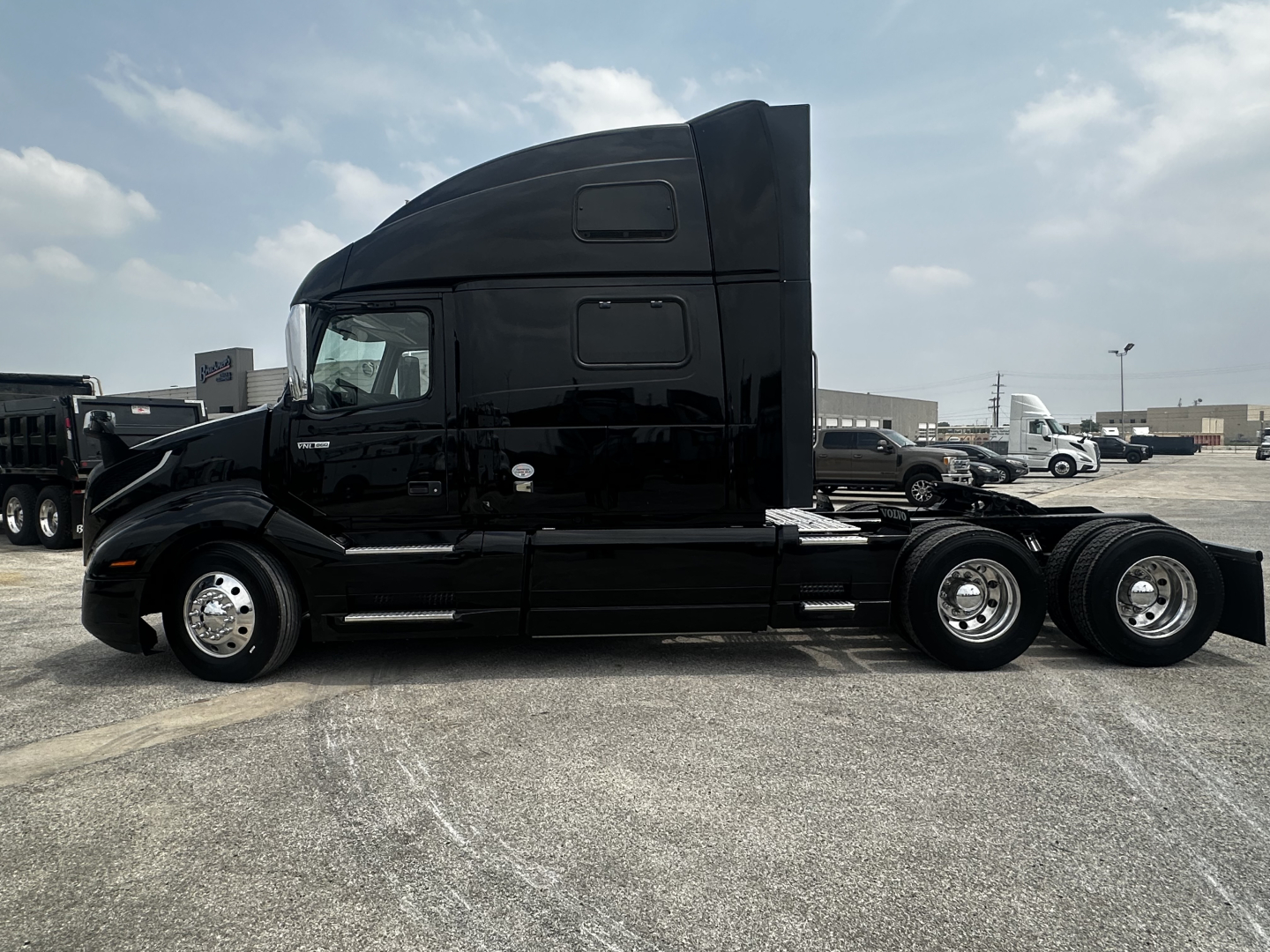 Volvo VNL860 semi truck side profile showing sleeper cab and dual rear axles in black paint.
