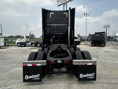 Truck rear view showing two mud flaps with ‘Buckner’s Trucks & Equipment’ logos, chassis, dual rear axles, and fifth wheel visible.