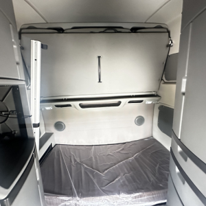Volvo VNL860 sleeper cab interior showing cargo area and rear wall with overhead storage hatch.