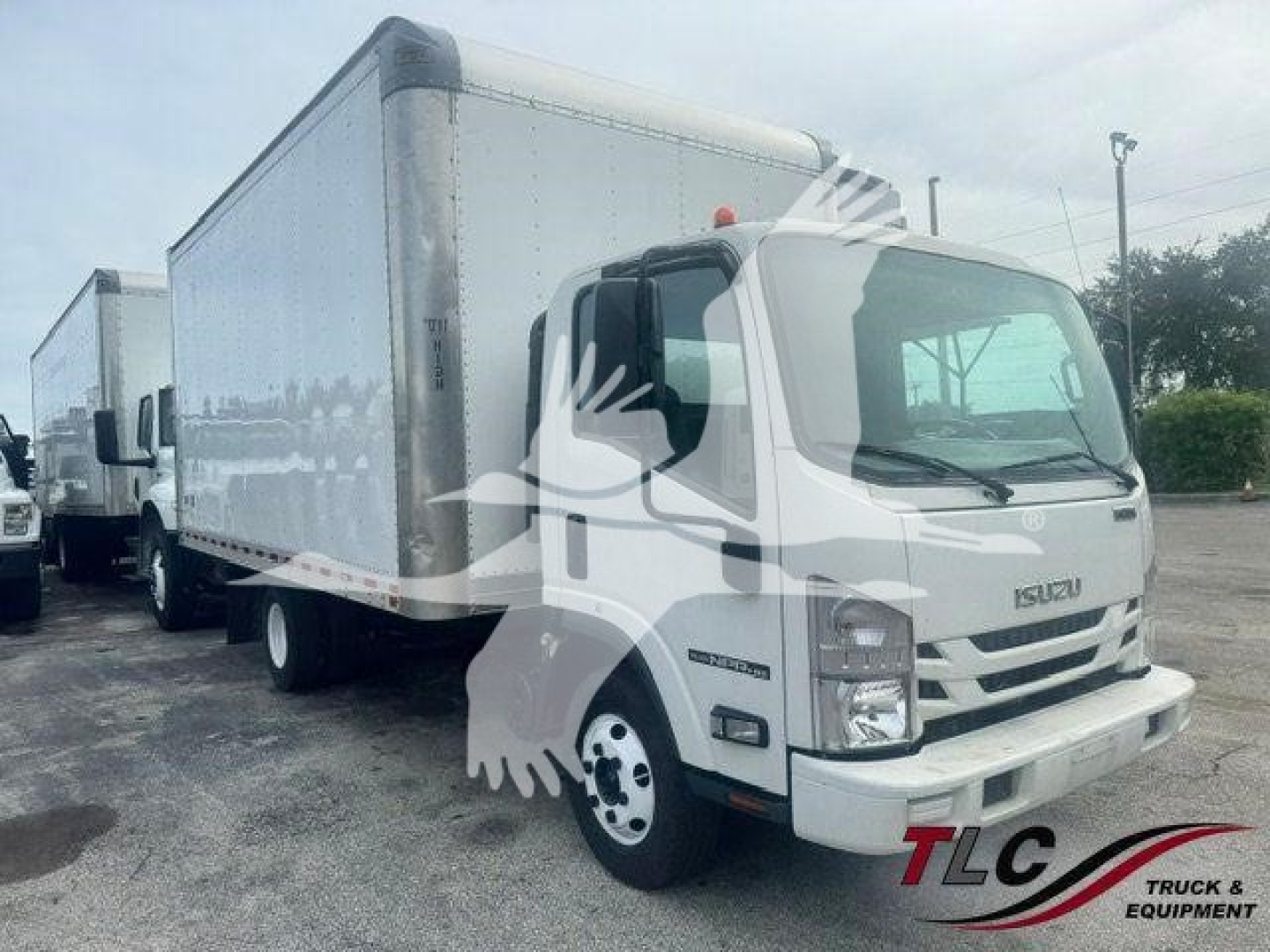 Isuzu NPR-HD box truck in service showing cargo box and cab with Isuzu grille and side mirrors.