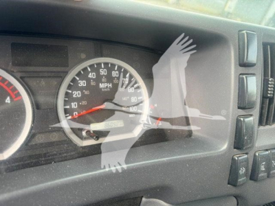 Isuzu NPR HD instrument cluster with speedometer and tachometer visible, dashboard controls on right, pilot view of odometer.