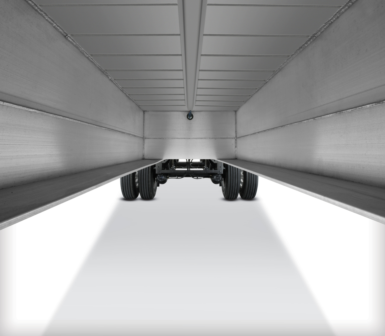 Underneath a Fontaine 48' aluminum flatbed trailer showing the underside beams and dual rear axles.