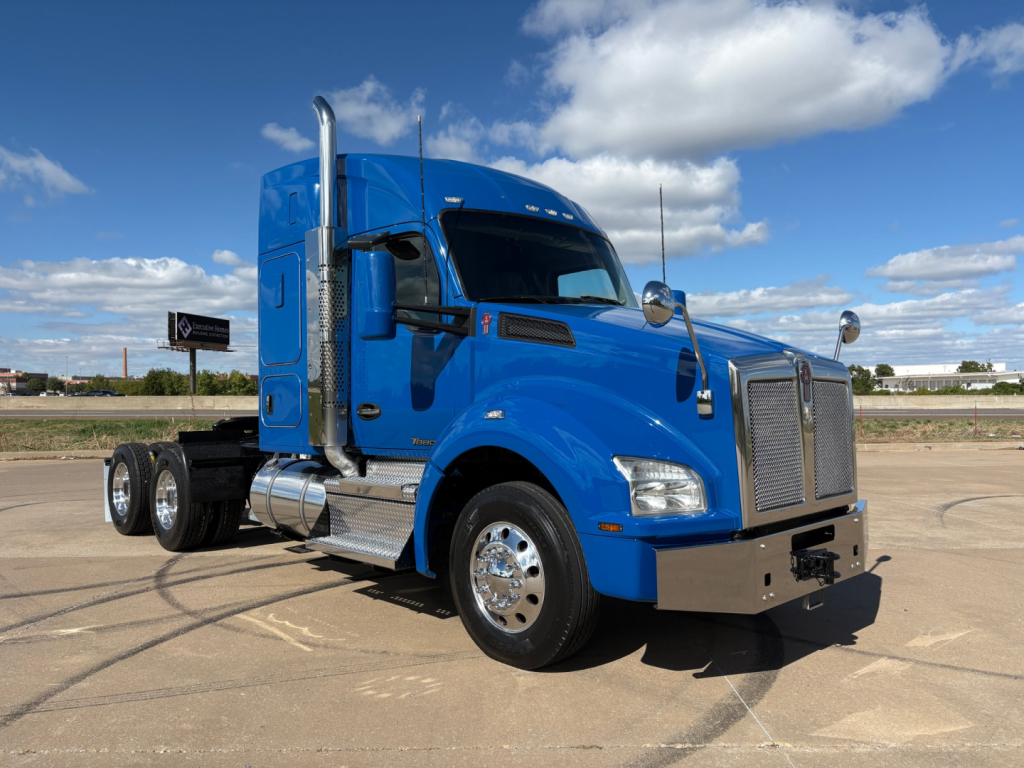 Kenworth T880 conventional sleeper truck in blue, front three-quarter view, with dual rear axles and chrome exhaust stacks.