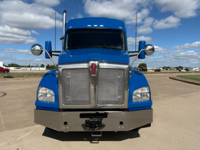 Blue 2020 Kenworth T880 front view showing large chrome grille, round mirrors, bumper, and emblem.