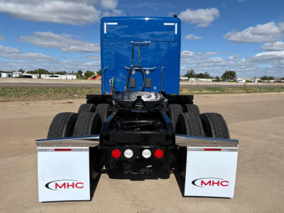 Kenworth T880 rear view showing dual rear axles, fifth wheel and mud flaps with MHC logos.
