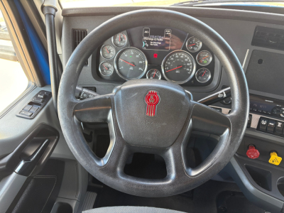 Kenworth T880 truck interior showing steering wheel with red emblem and instrument cluster