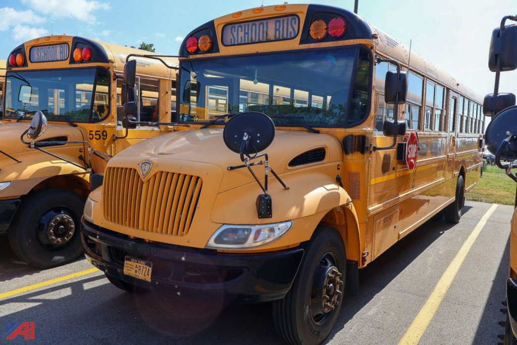 School bus front view showing CE Series label and round mirrors with 'SCHOOL BUS' sign on roof in a parking lot.