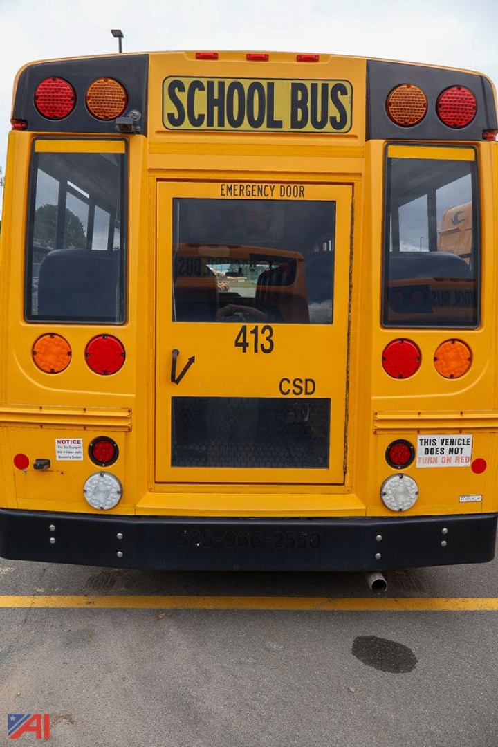 Rear view of a yellow school bus with 'SCHOOL BUS' sign, emergency door, red taillights, and bus number 413 visible.