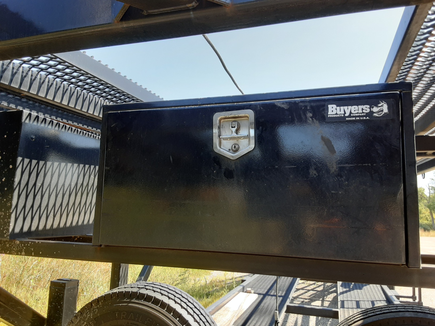 Trailer toolbox mounted on a car carrier trailer with Buyers logo sticker visible