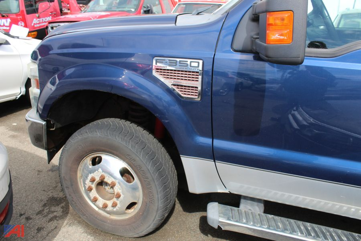 Ford F-350 Super Duty truck side view showing front fender badge, wheel, and running board; blue cab with chrome Steve step. 