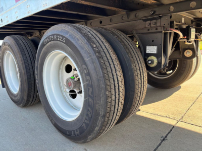 Trailer rear wheels and undercarriage showing dual axle with Gen-2 tires and light gray rims.