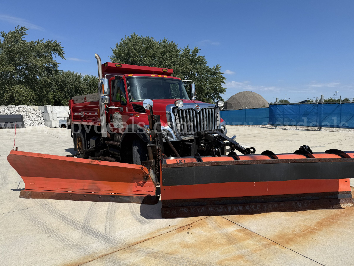 Heavy red dump truck with large orange snowplow blade attached in front, International 7400, VIN 1HTWDAAR3CJ681399, stock 29632-7, category dump truck.