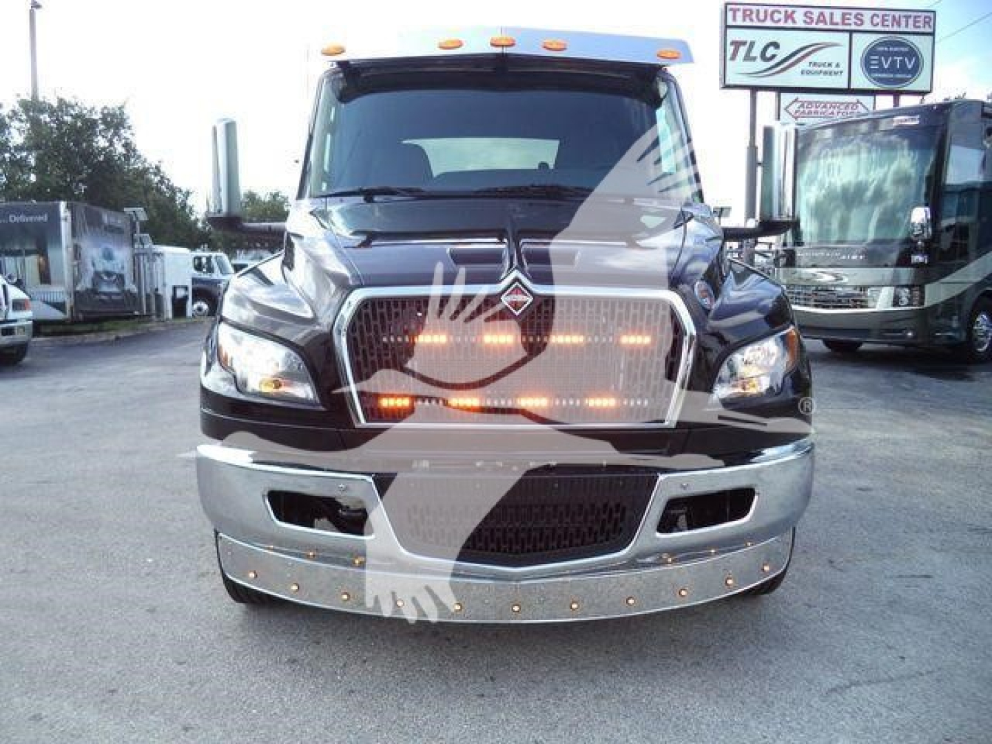 Black 2027 International MV truck front view showing chrome grille, bumper, and LED daytime running lights.