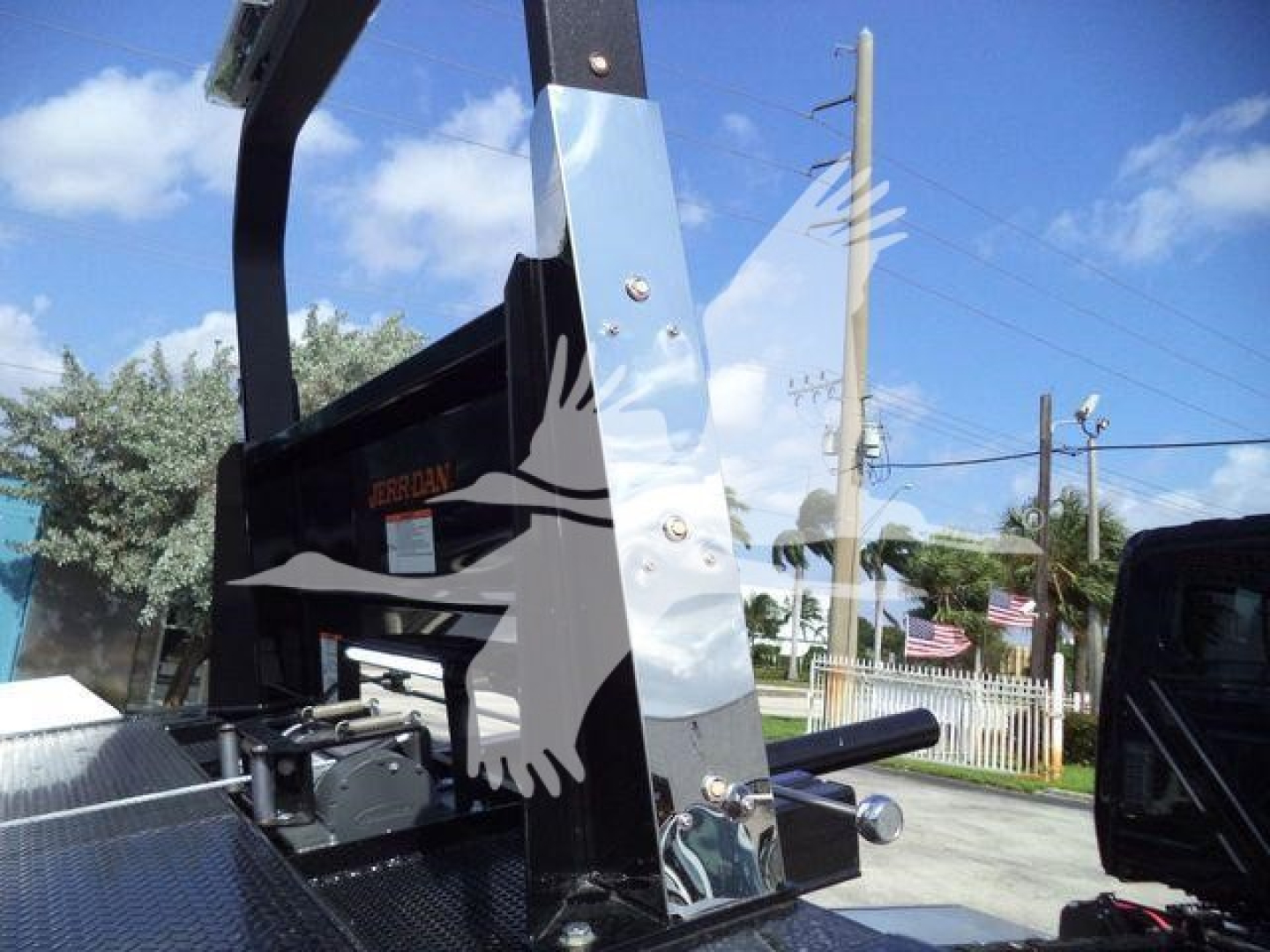 Truck chassis of a 2027 International MV rollback equipment showing hydraulic lift and metal frame with black and chrome components.