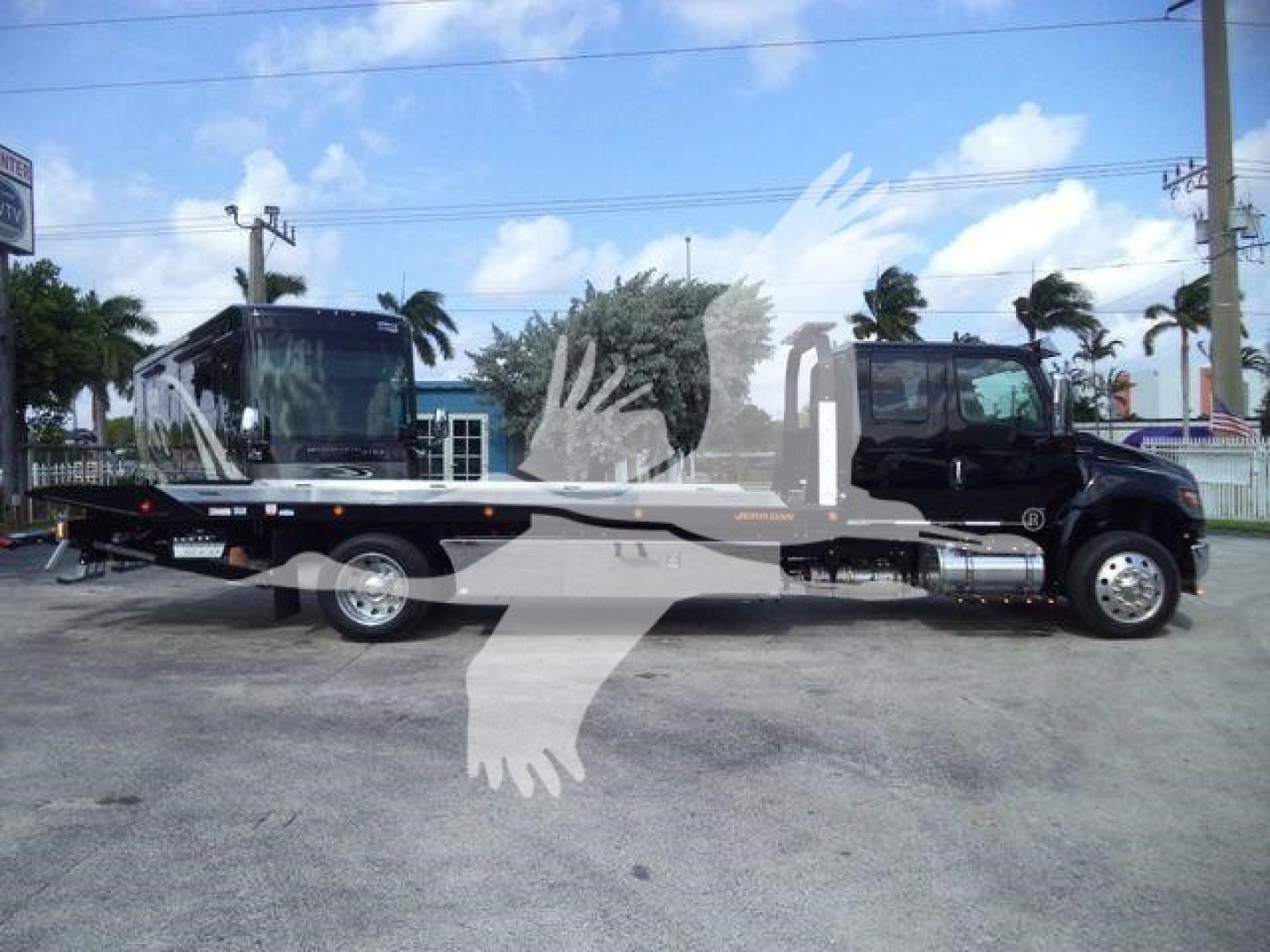 2027 International MV tow truck/rollback with a flatbed and black cab, side view showing long flatbed, dual rear wheels, and chrome fuel tanks.