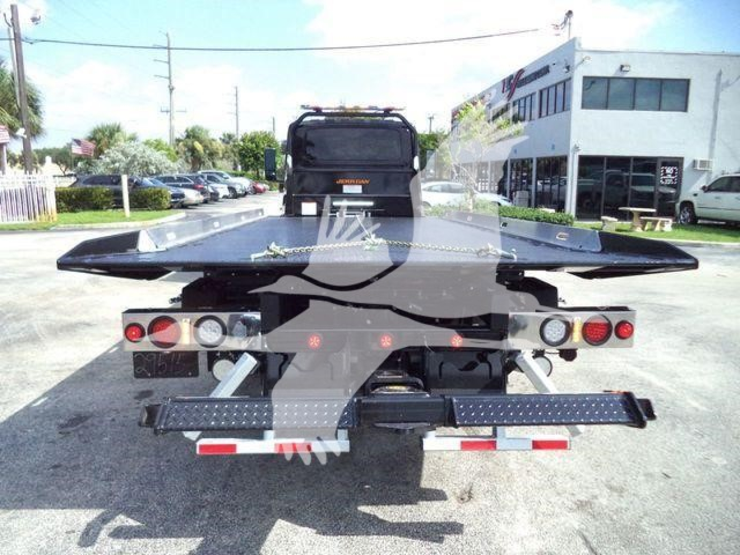 Rear view of a 2027 International MV rollback truck showing flatbed and platform with taillights and bumper.