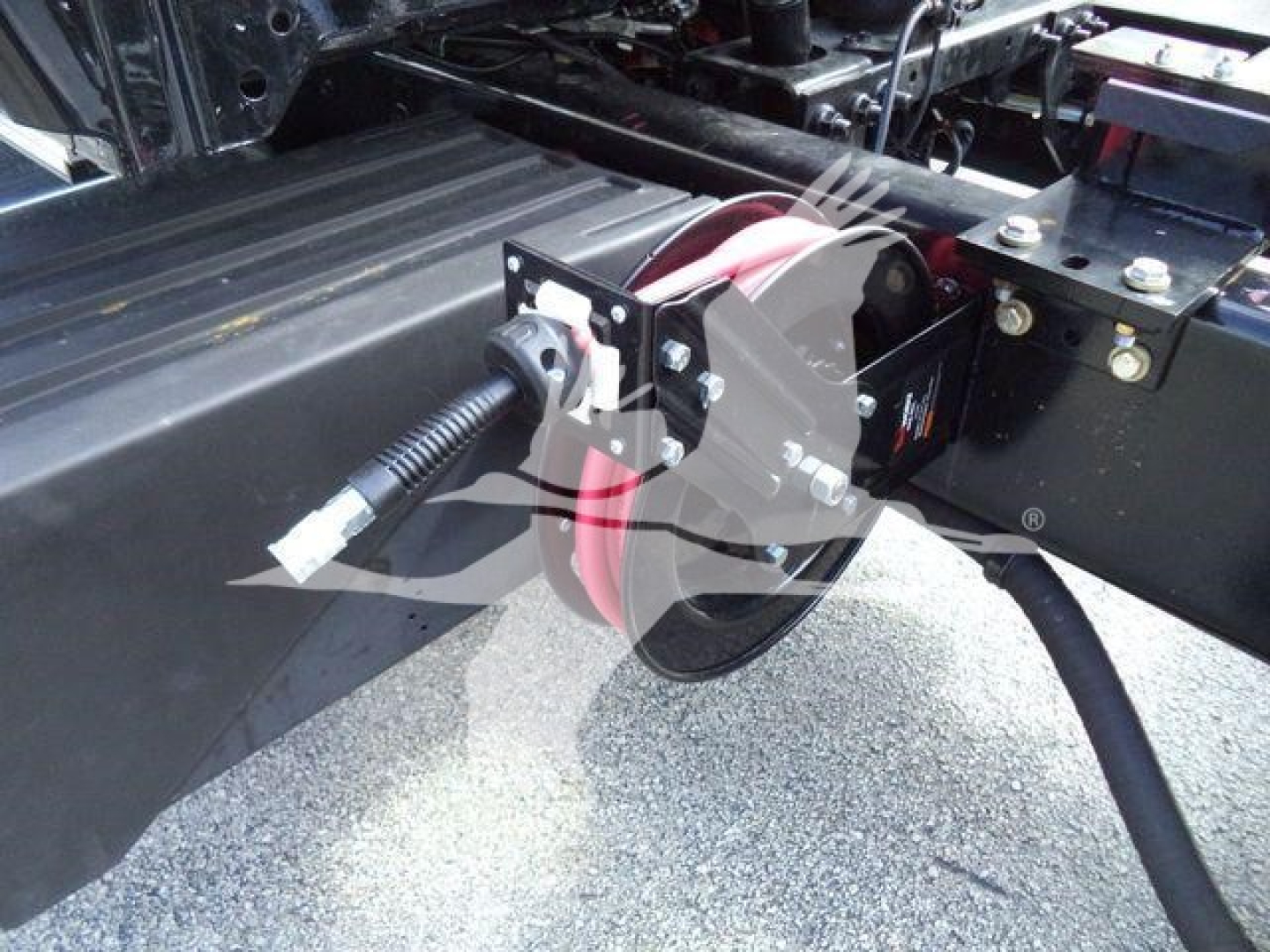 Truck chassis with winch/roller and wiring harness visible; includes red cable reel and black metal brackets near the frame