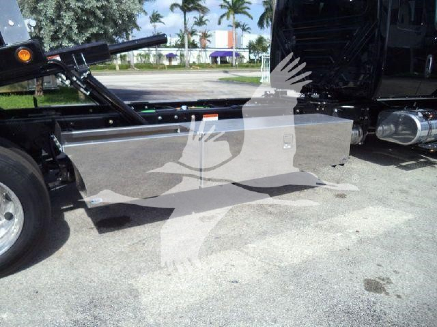 Truck side view showing a large metallic toolbox/side panel mounted on International MV rollback truck chassis.