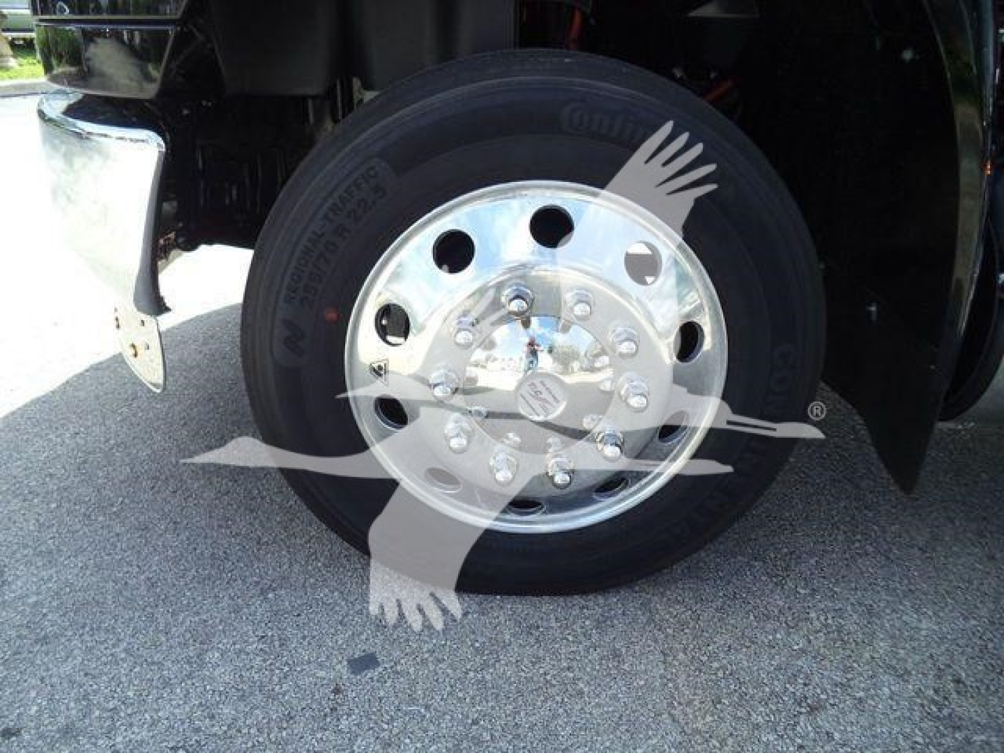Wheel/tire and polished steel hub on a truck front axle showing tire brand and lug nuts.