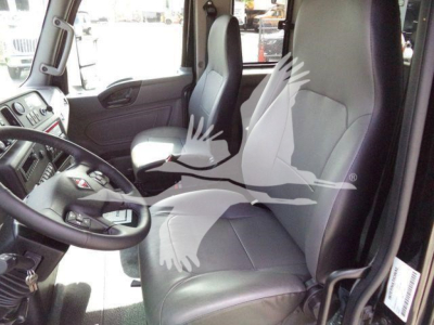 Cab interior of a 2027 International MV truck showing driver seat, steering wheel, and passenger seat in view with light gray upholstery.