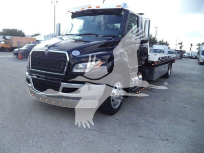 Tow truck with flatbed showing black exterior and chrome grille, International MV series badge, in-service equipment, front view with bumper lights.