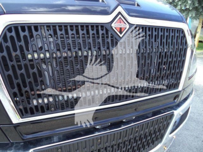 Front grille of a 2027 International MV truck showing the large black honeycomb grille and the International badge on the hood.