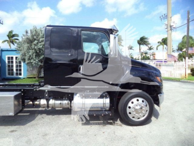 Truck cab side view showing black semi-truck with chrome fuel tanks and wheel, clean body panels, side profile mirror, and chassis components.