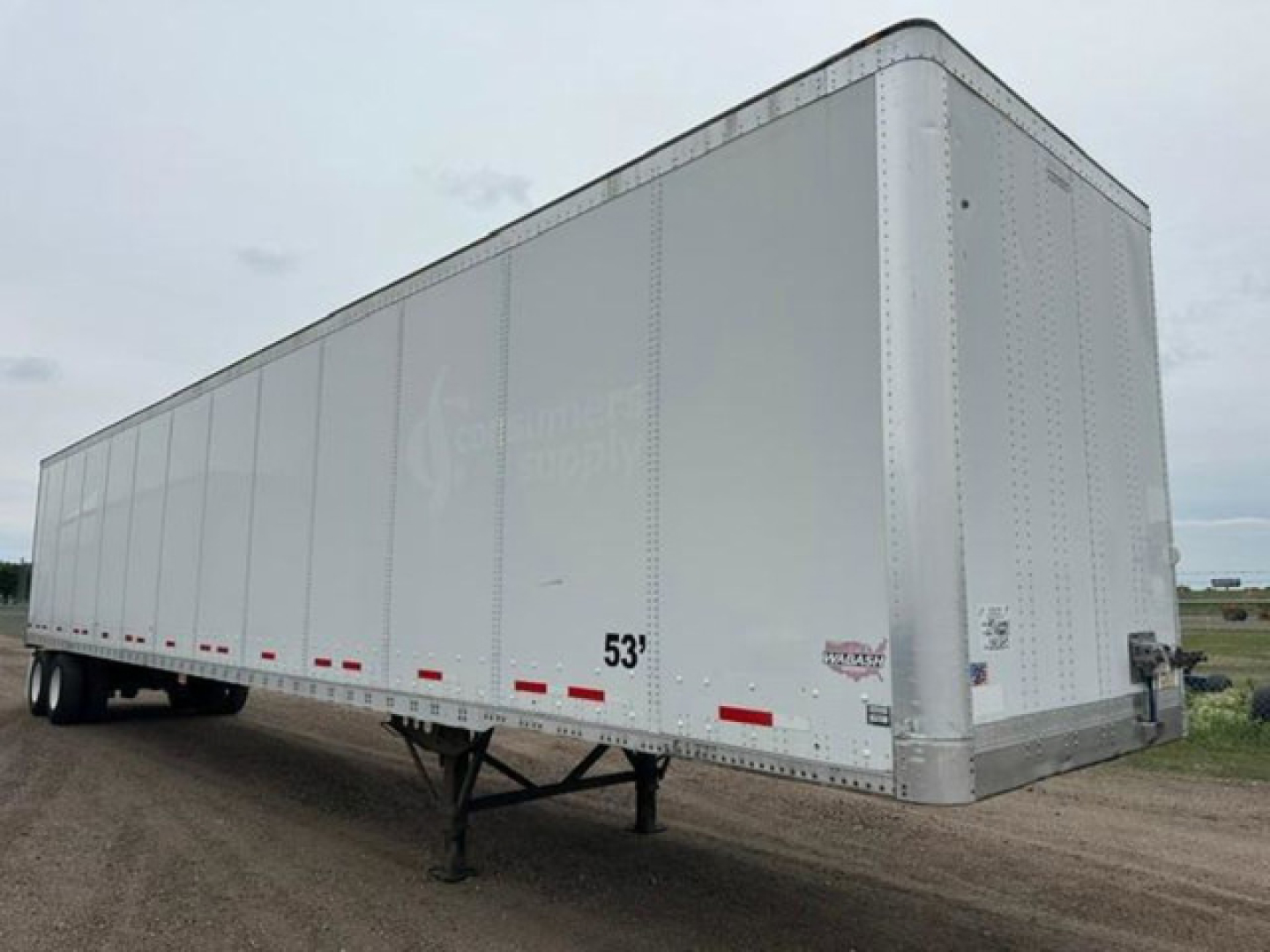 Trailer side view of a 53' Wabash dry van with silver exterior and dual rear axles, front nose, and landing gear visible.