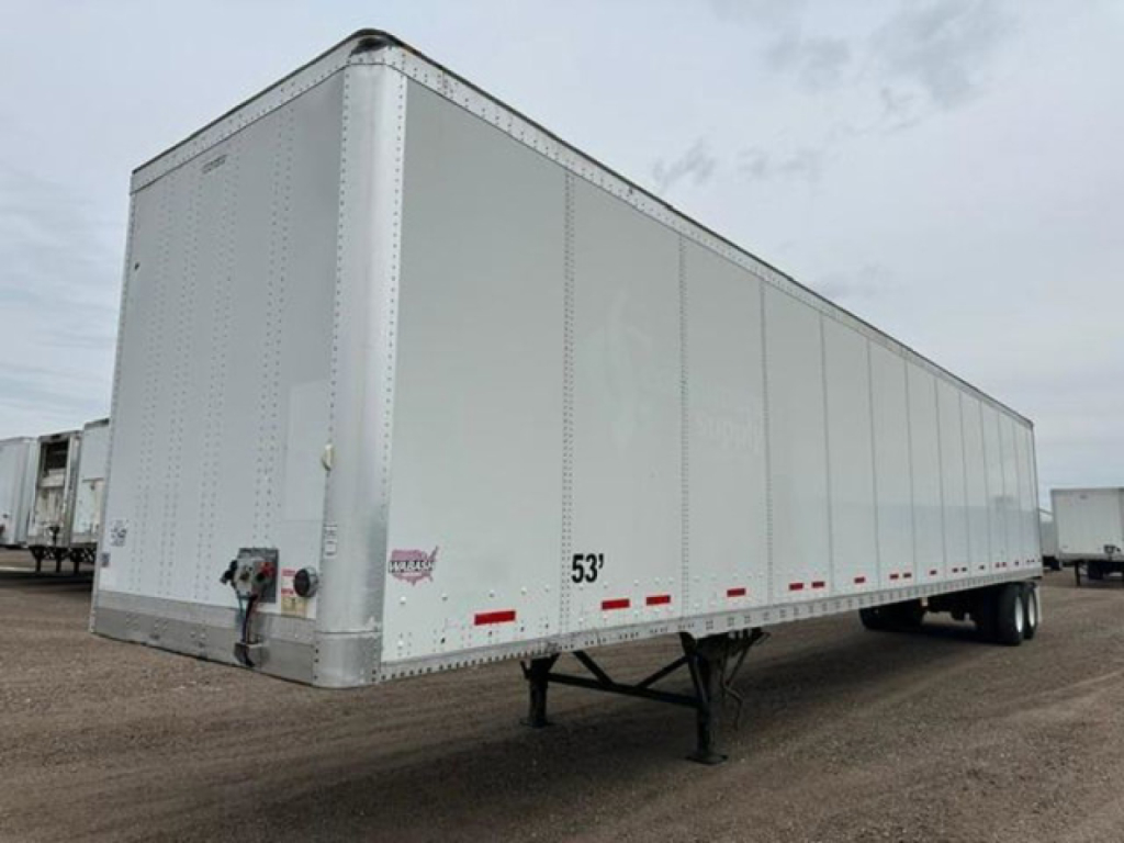 53' white Wabash van trailer with standard box, front control box and dual rear wheels visible; jack stand under front corner, VIN sticker not readable from image.