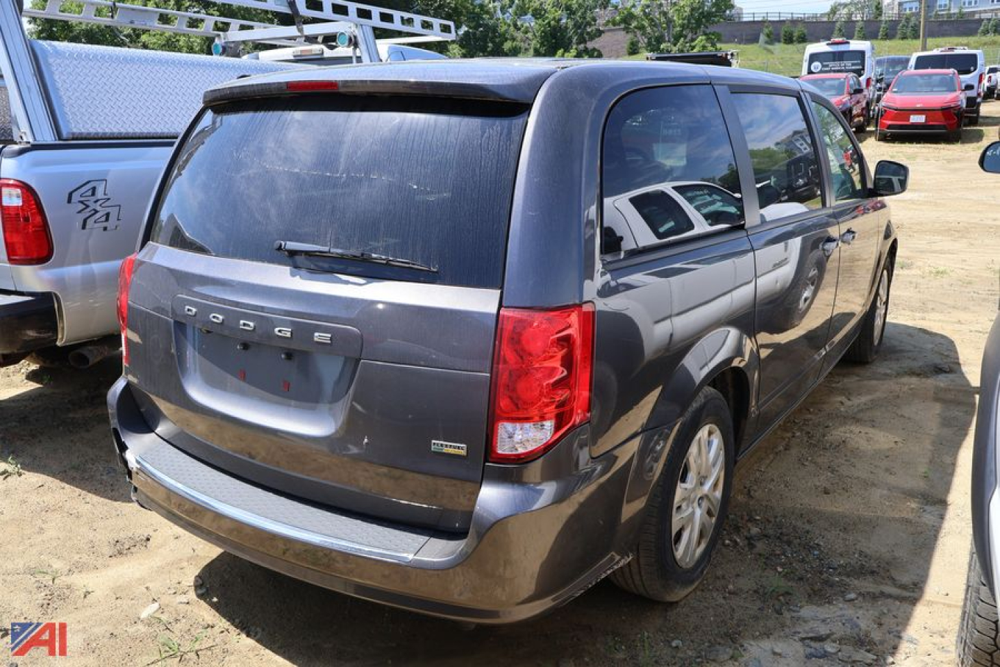 Dodge Grand Caravan minivan rear 3/4 view showing tinted windows, rear wiper, and Dodge emblem on tailgate.