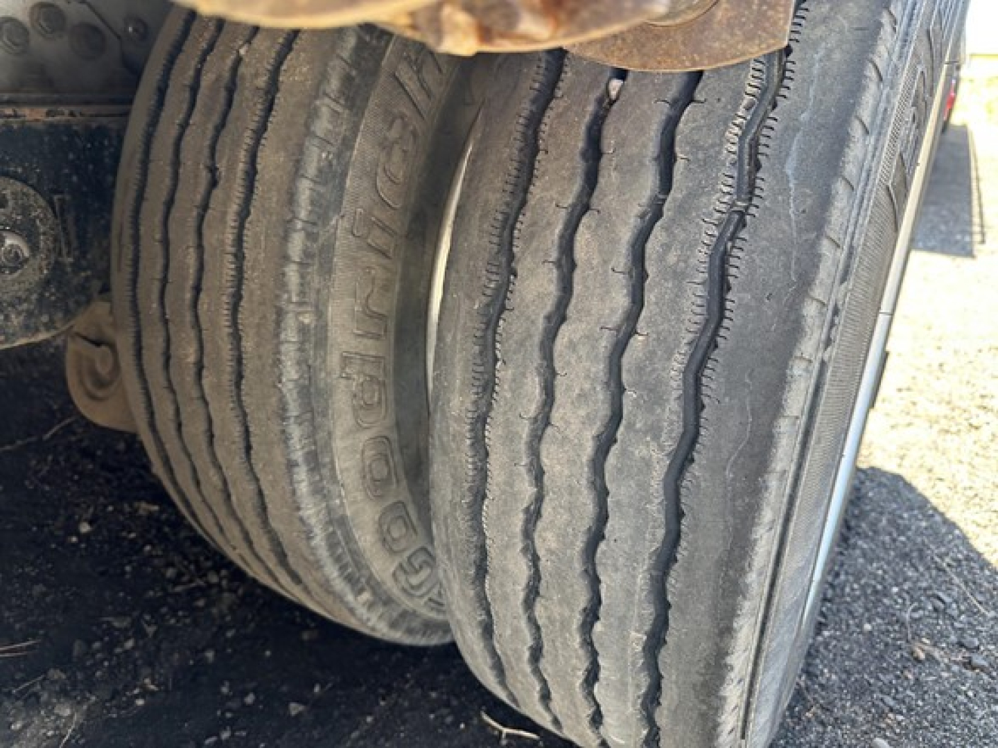 Dual rear tires of a 2014 Reitnouer aluminum drop deck trailer showing tread pattern and sidewall text.