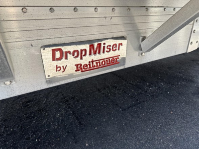 DropMis­er by Reitnouer plate on aluminum drop deck trailer showing side rails and ramp area.