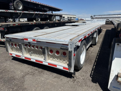 Flatbed trailer showing aluminum drop deck with rear ramps and two toolbox boxes, rear and side lighting, metal diamond plate decking.