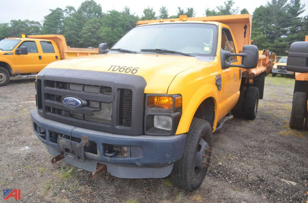 Ford F-350 chassis cab dump truck in-service showing front grille, TD666 decal, and yellow body with plow-ready bed