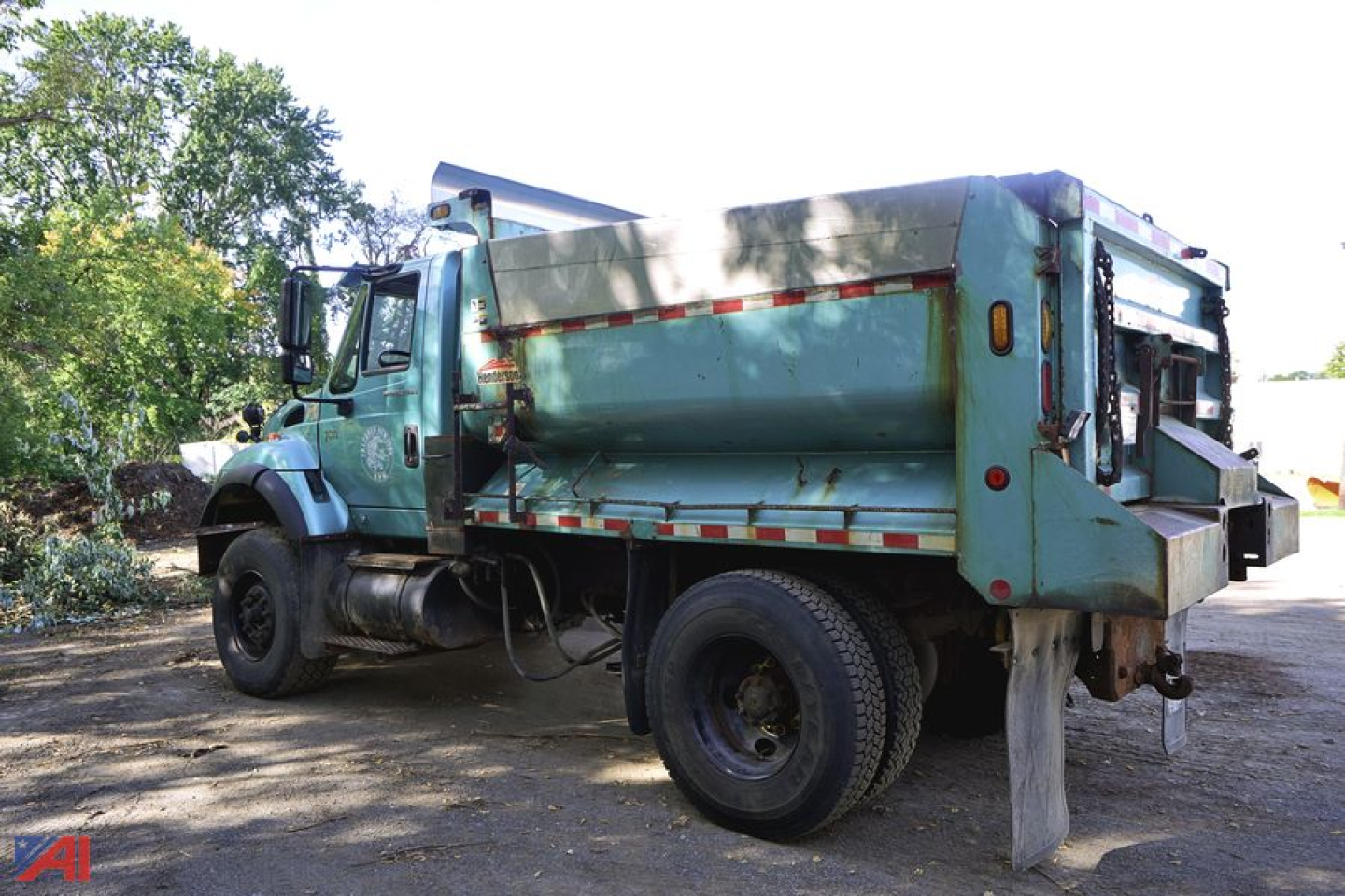 International SA647 WorkStar 7600 dump truck with plow, side view showing green dump body, dual rear wheels, and plow mount.